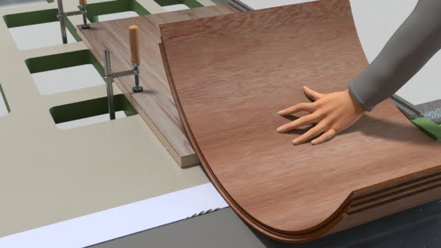 横切り盤に置いた成型合板を手で押さえる